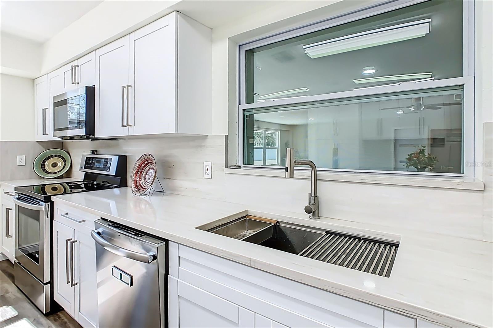 Updated kitchen sink and prep area with modern fixtures and finishes