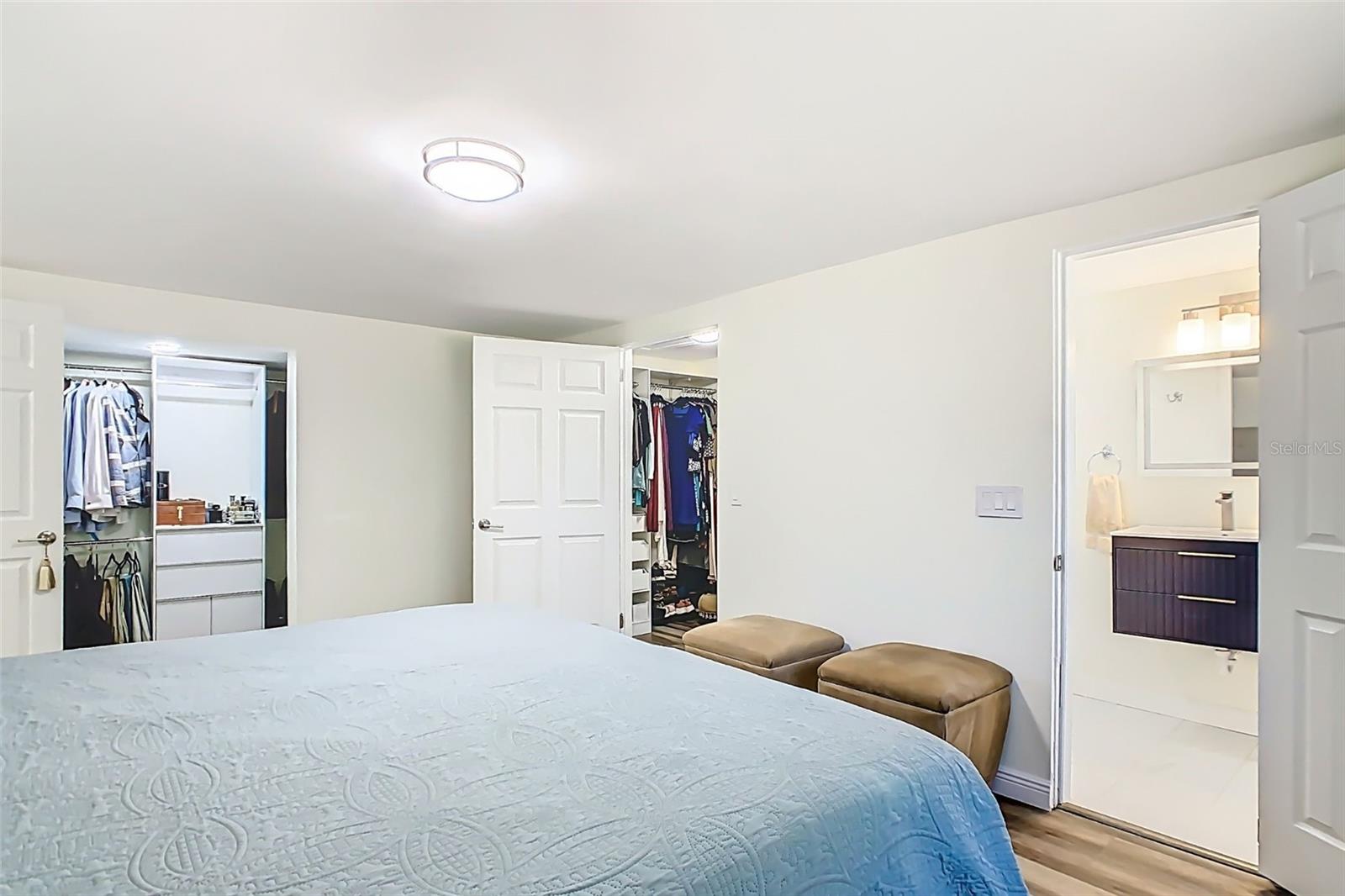 Primary suite view showcasing en-suite bath and dual walk-in closets