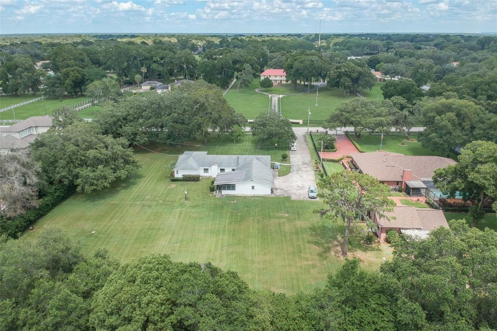 Wide aerial view showing surrounding estate properties and neighborhood setting.