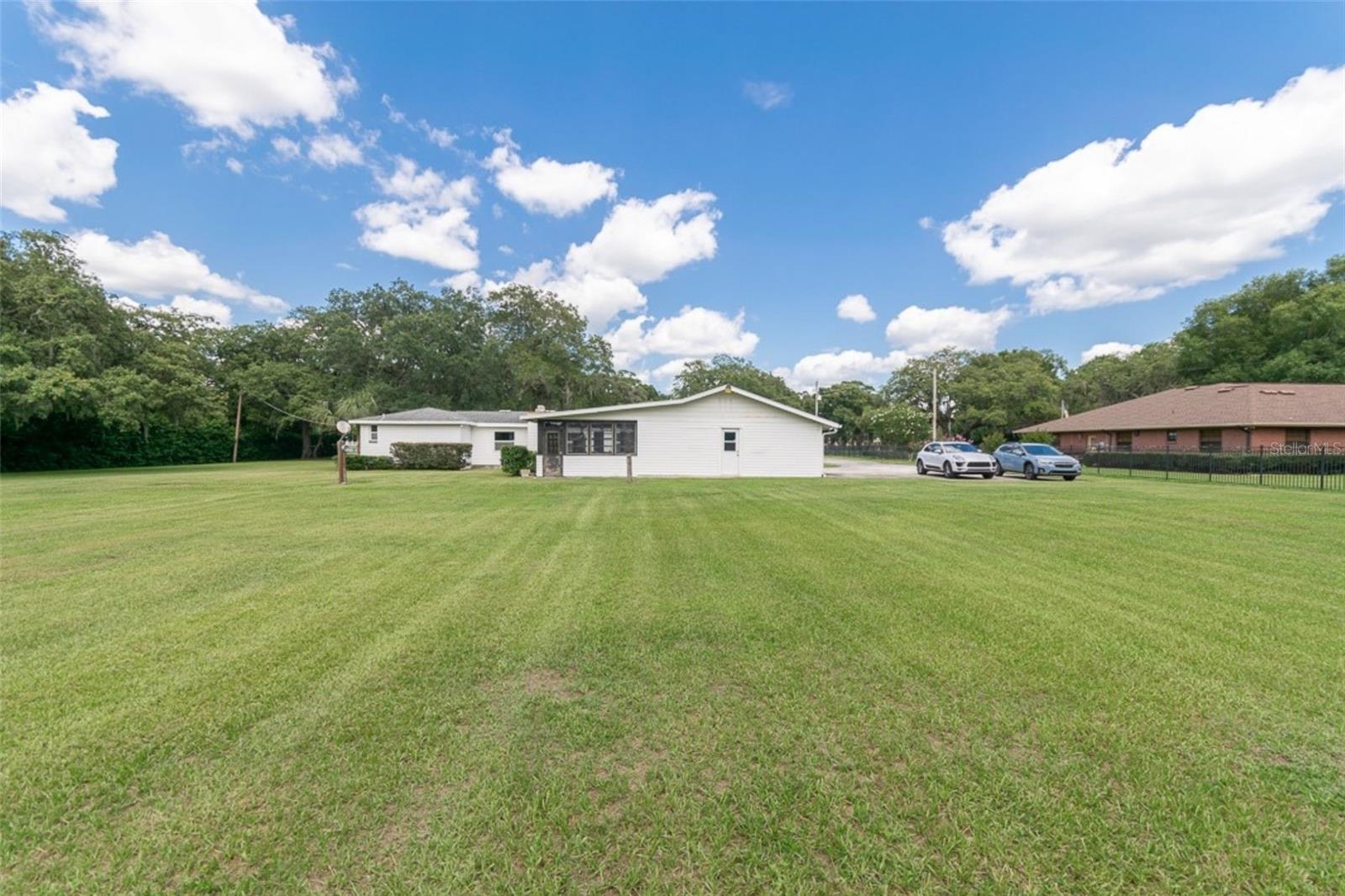 View from barn toward residence highlighting open grounds and depth of lot.