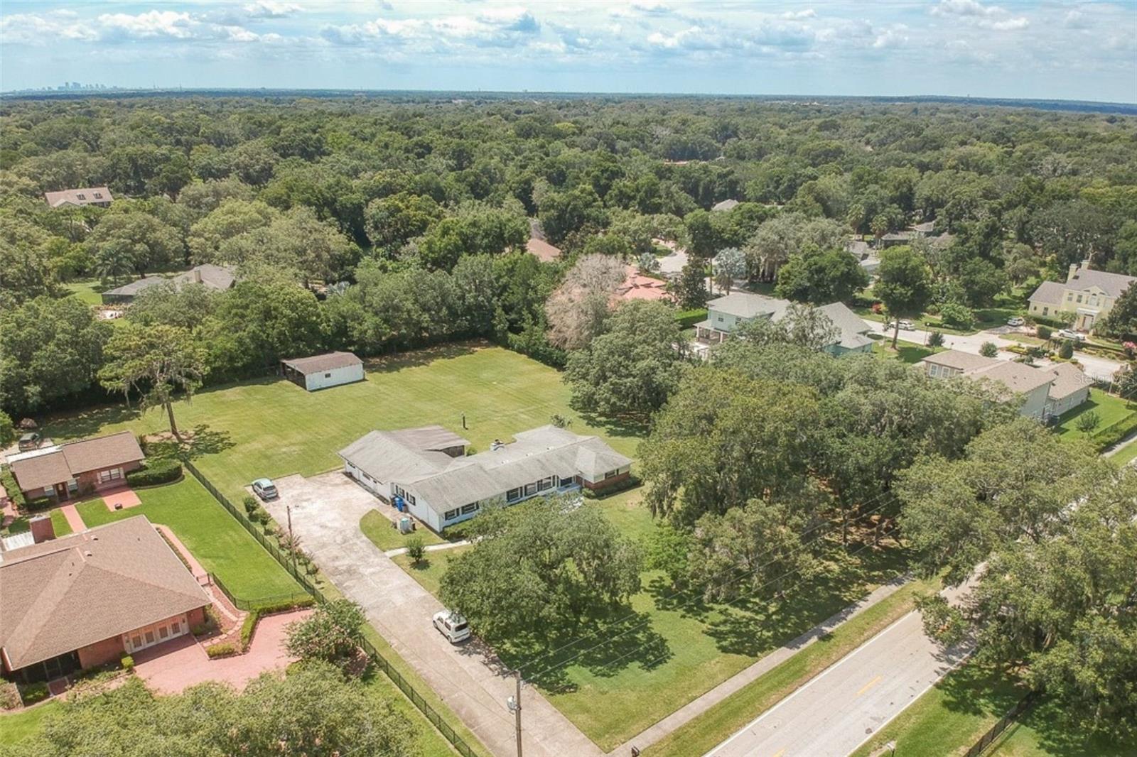 Front aerial view showing driveway approach and overall property setting.
