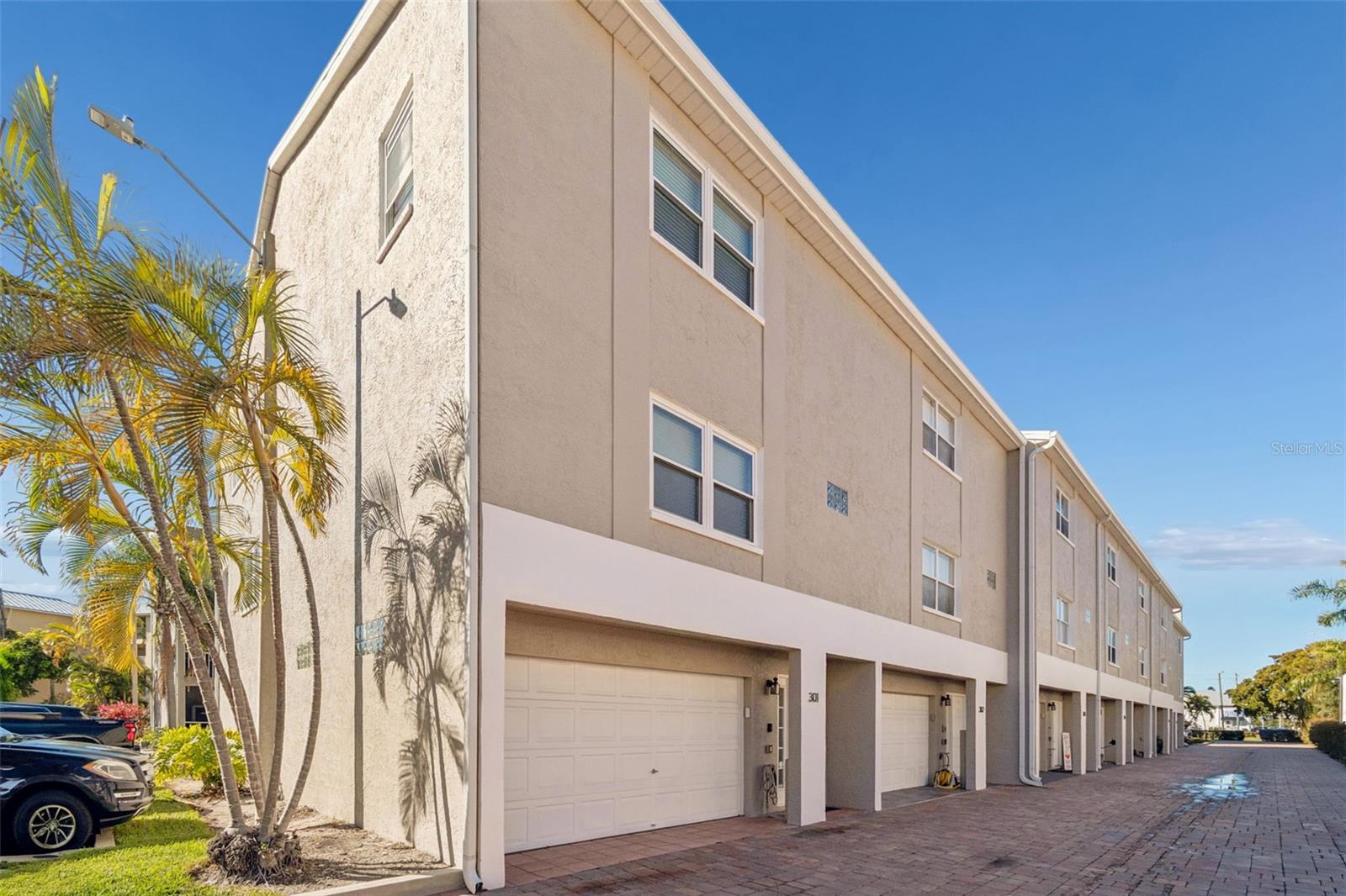 Corner-unit exterior with two-car garage, added privacy, extra natural light, and convenient location next to guest parking in a well-maintained coastal-style community