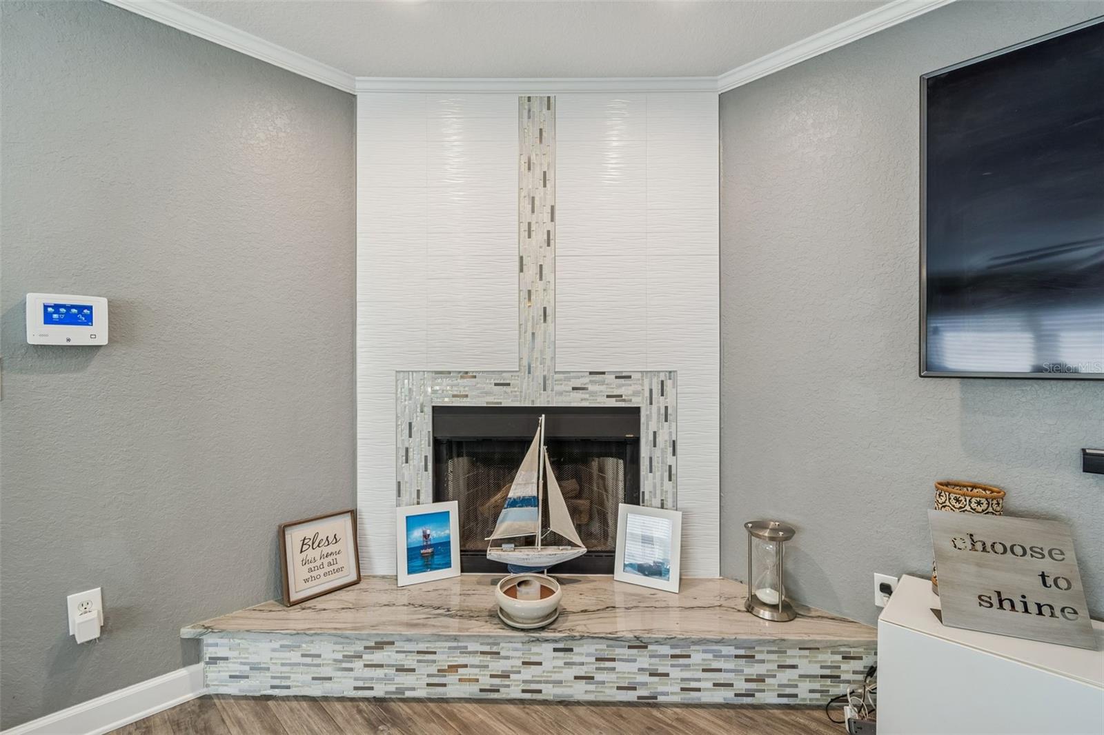 Sleek floor-to-ceiling tiled fireplace with modern mosaic accent detail.