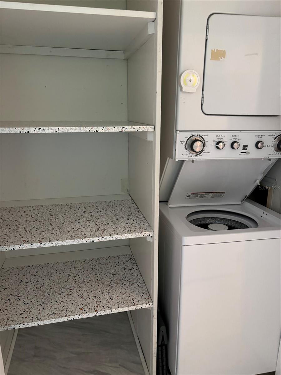 Large kitchen pantry and stacked washer and dryer in kitchen