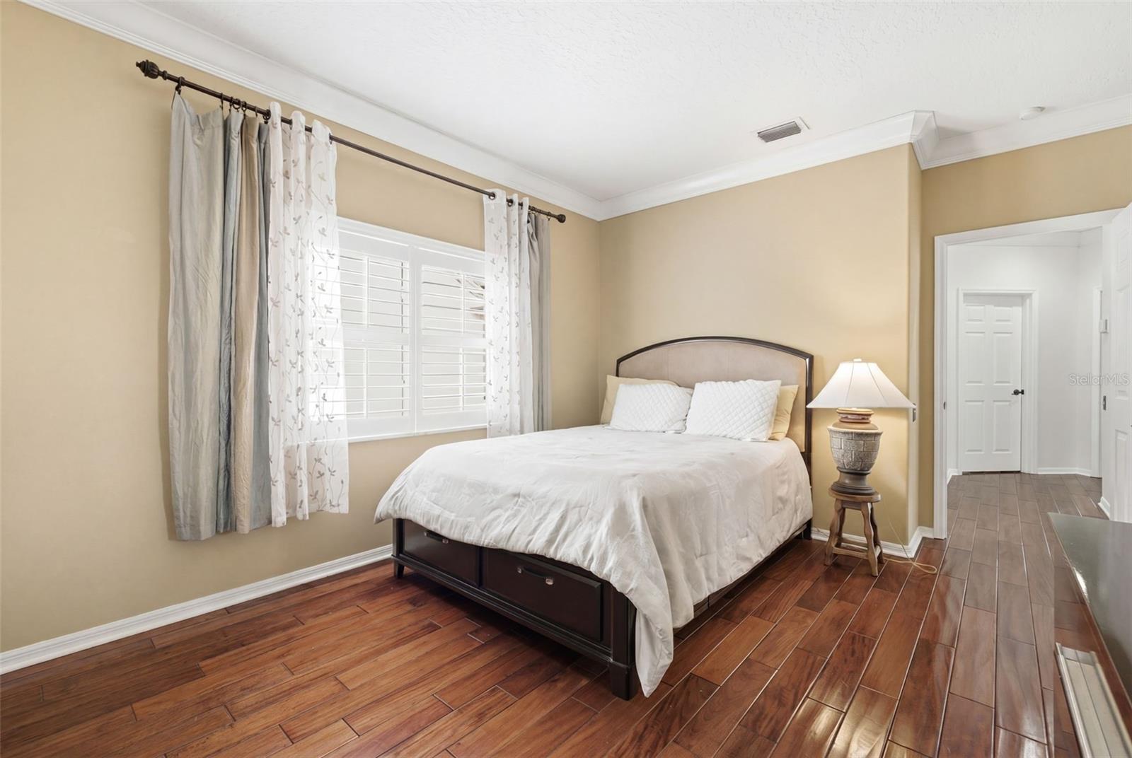 Guest bedroom 1 with mahogany wood floors.