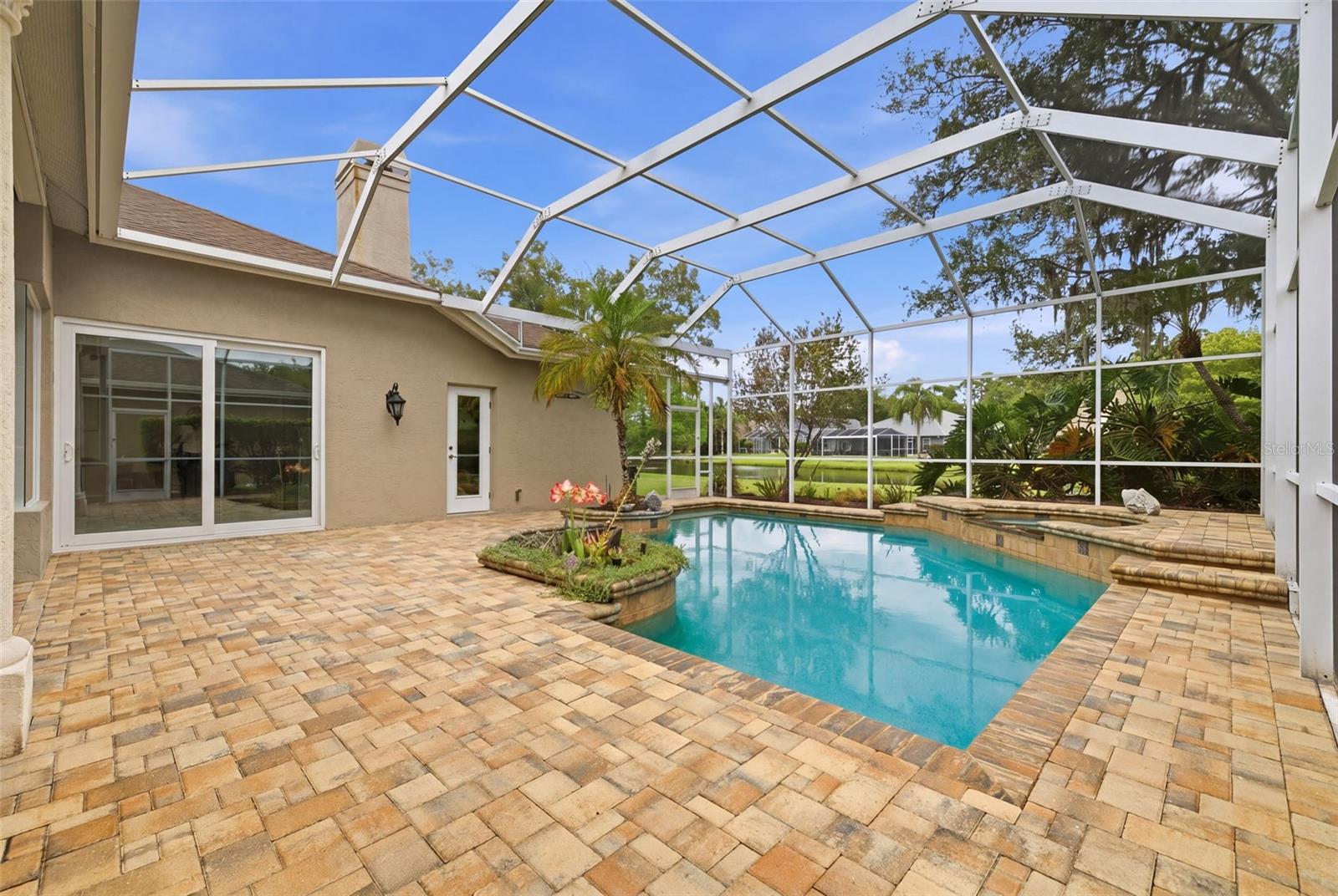 Fully remodeled pool deck with view to pond.