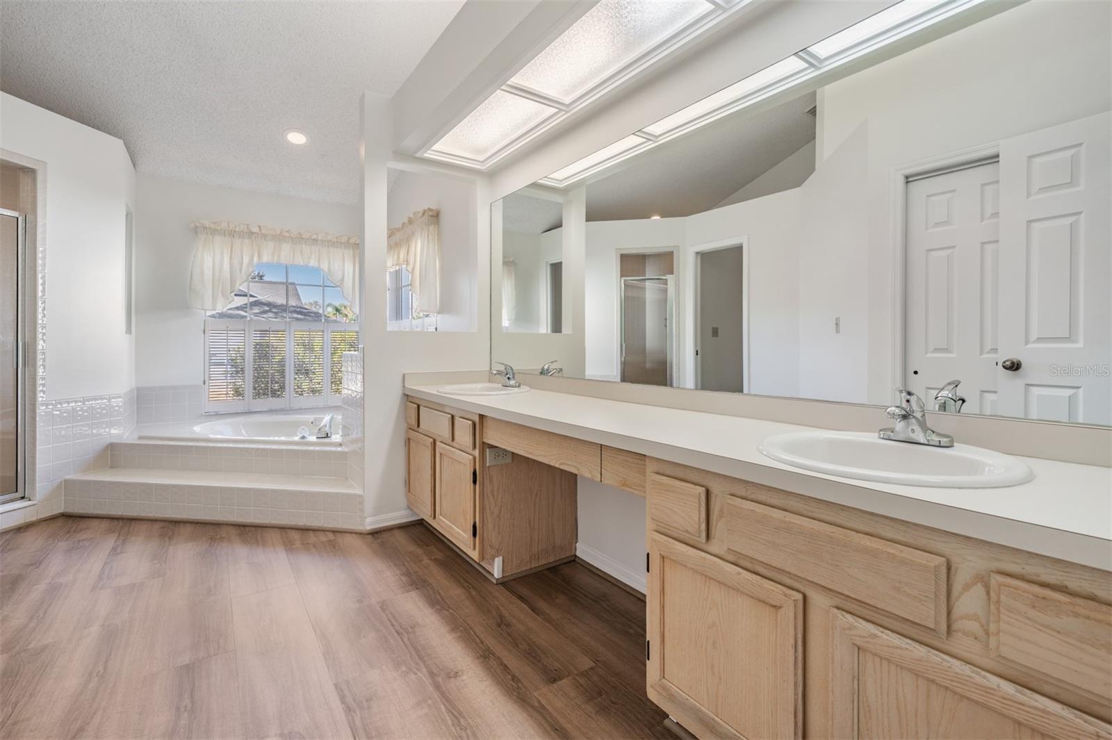 Bath ensuite with dual sinks, soaking tub and separate shower