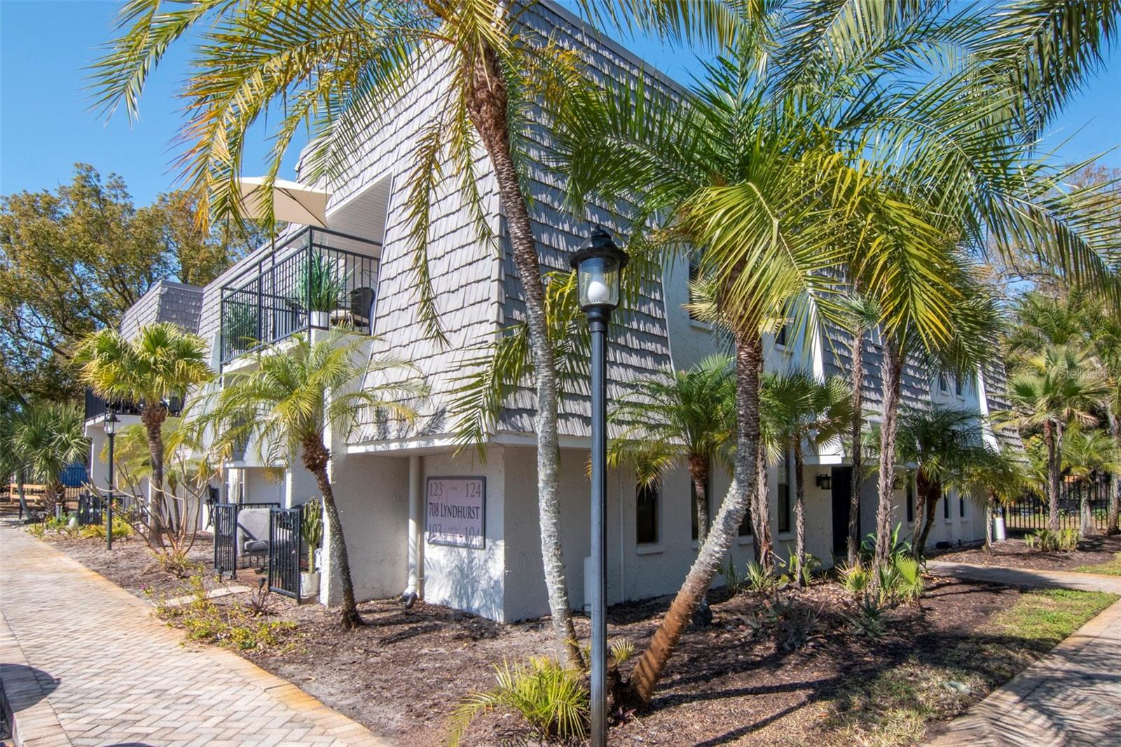 Front Exterior showing unit balcony with tan outdoor patio umbrella