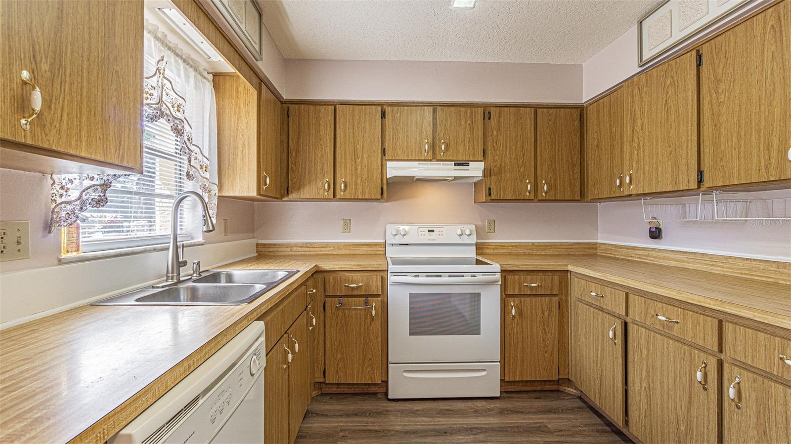 Loads of cabinets! Smooth top range in this bright kitchen