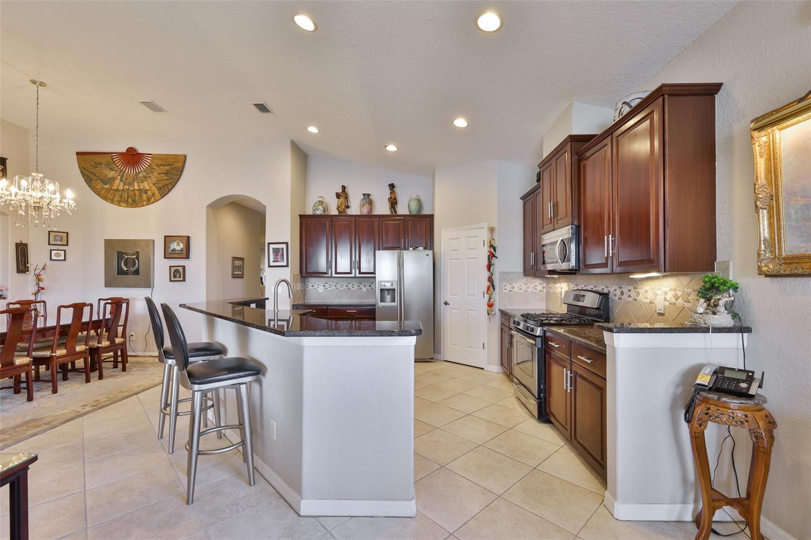 The kitchen is large enough for two, with stainless-steel appliances, gas range, granite counters, a walk-in pantry and cherry all wood cabinets.