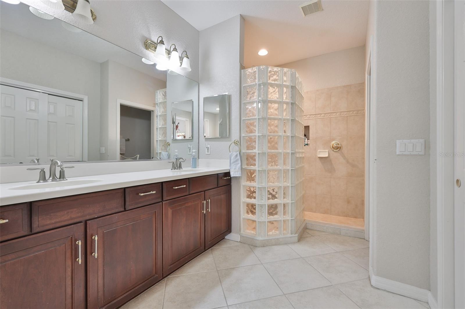 The owners bathroom is beautifully detailed with cherry cabinets and a privacy glass wall in the shower.