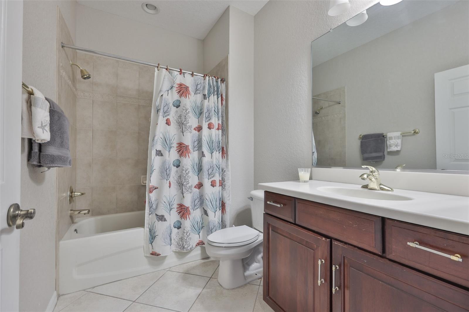 Guest bathroom is located next to the spare bedrooms for convenience and privacy.  With matching cabinetry as in the rest of the home.