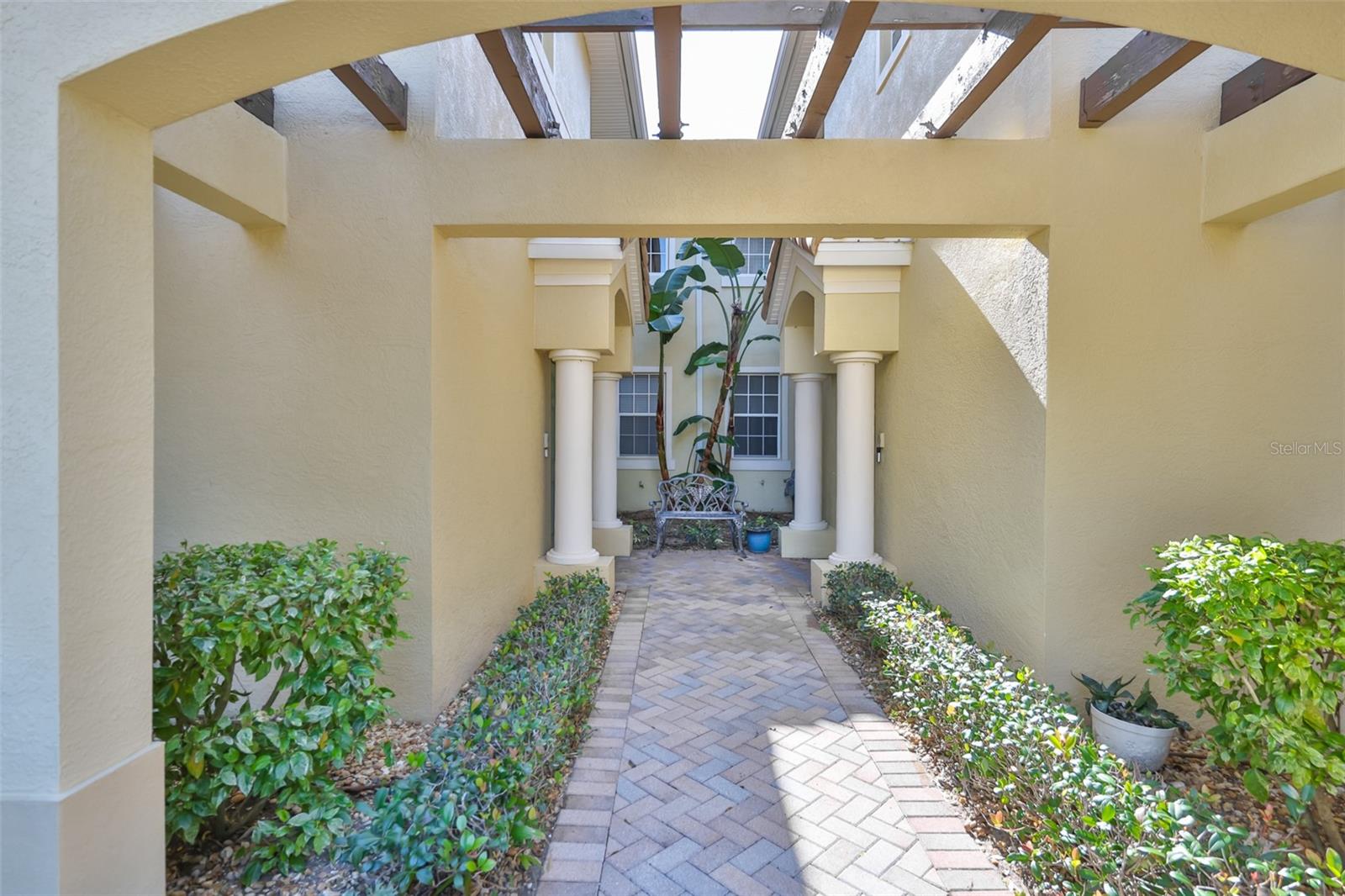 Private entrance to the upstairs unit is located through the portico from the beautifully pavered walkway.
