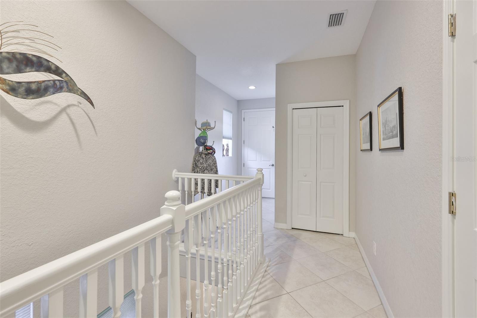 When you get to the top of the stairs, the elevator is located to the back center of the picture. Notice the bright recessed lighting and sunshine filtering into the condo.