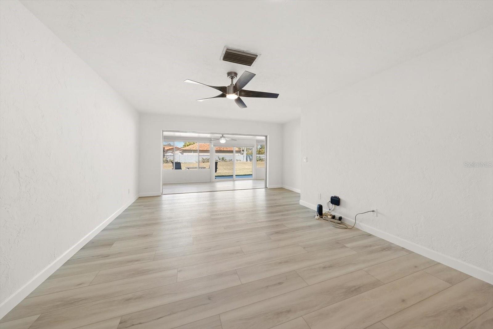 large open living room, dining room combo with sliders out to the Florida room