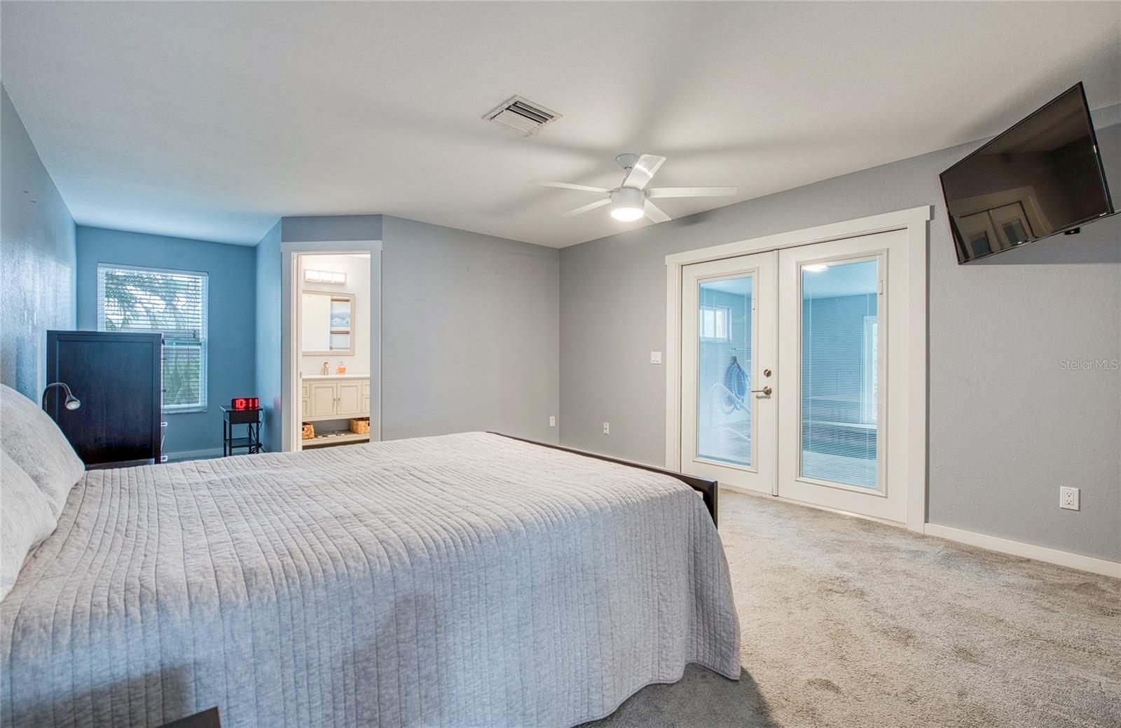 First Floor Primary Bedroom with En Suite and French Doors closed to Pool Area