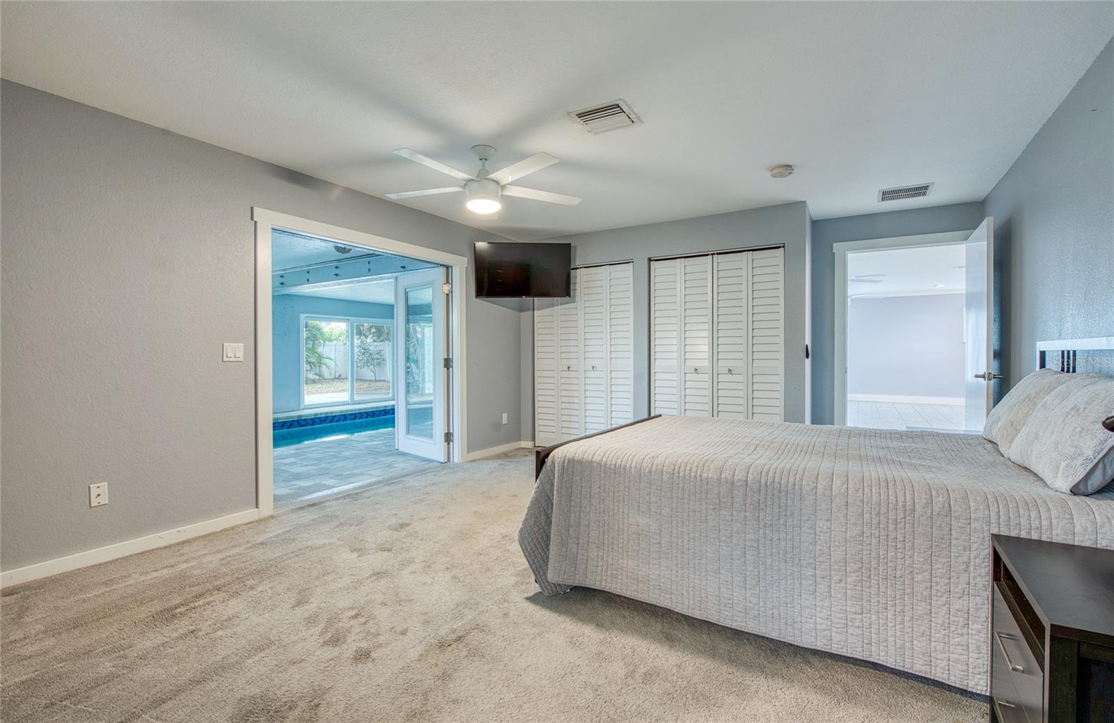 First Floor Primary Bedroom open to Living Area and French Doors open to Pool Area