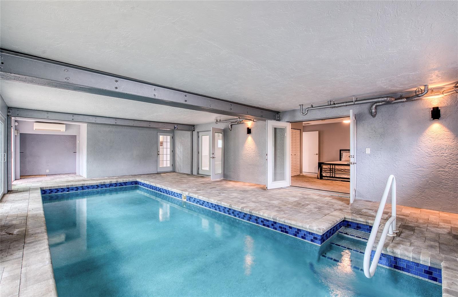 Indoor Pool Area with French Doors to Living Area open and access to inside stairway