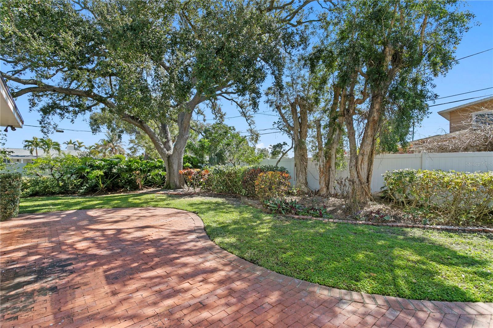 Backyard, pavers and fully landscaped with trees and privacy fencing