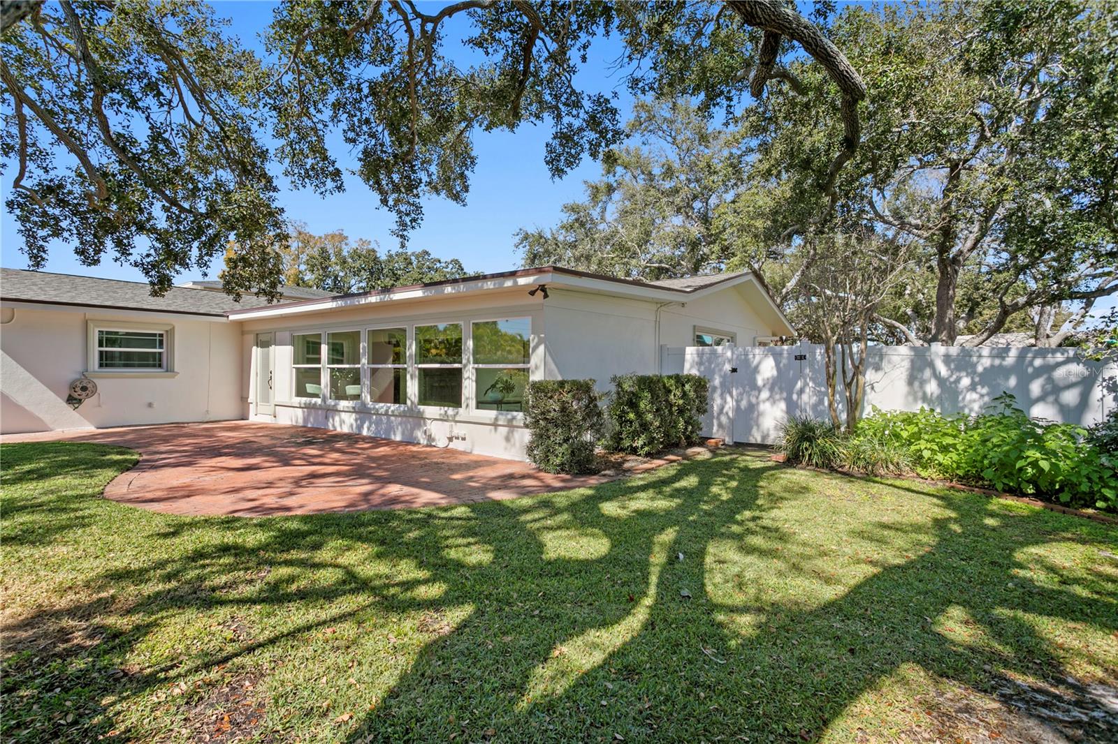 Backyard, pavers and fully landscaped with trees and privacy fencing