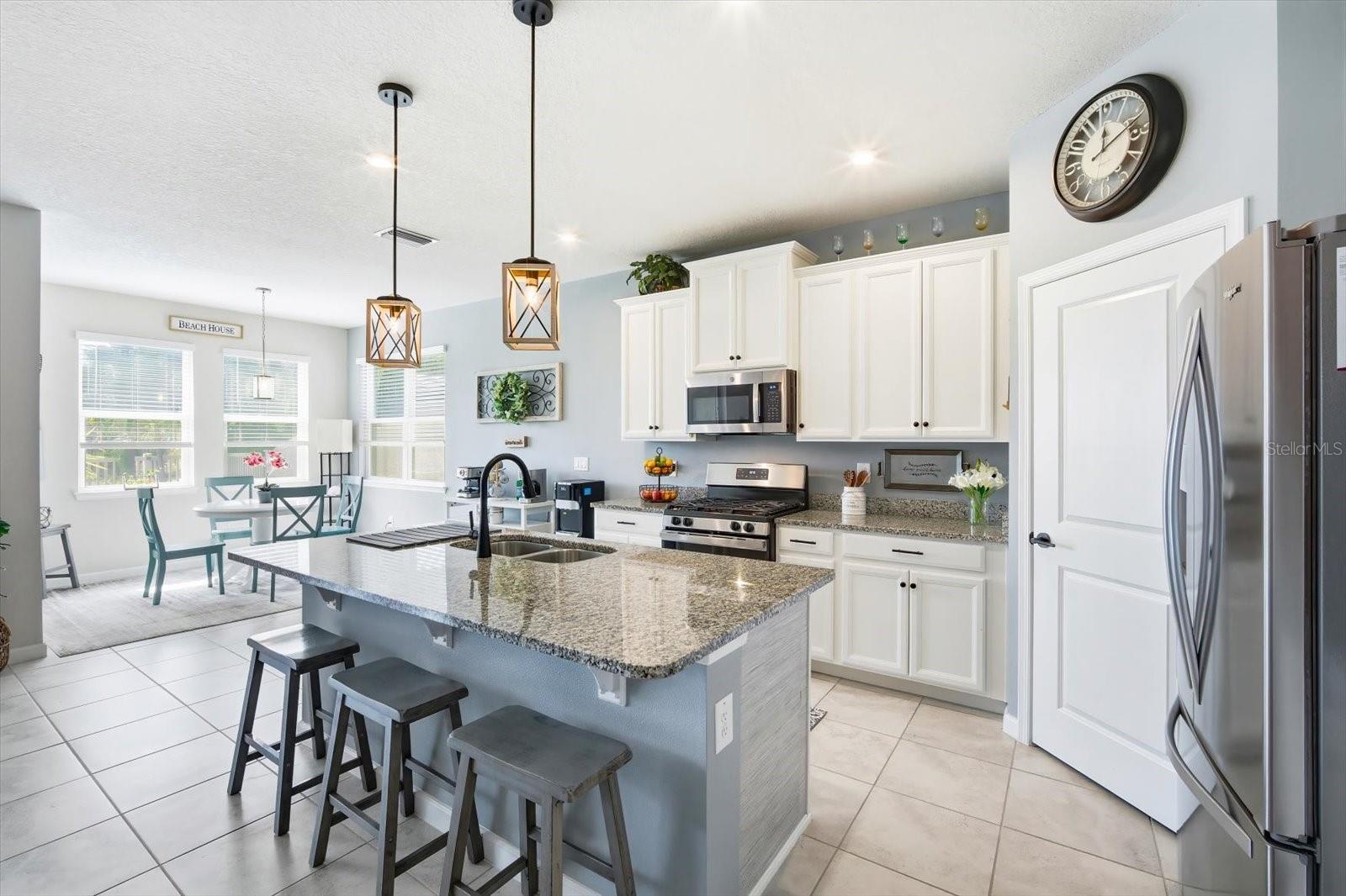 Open kitchen with stainless steel appliances and granite countertops