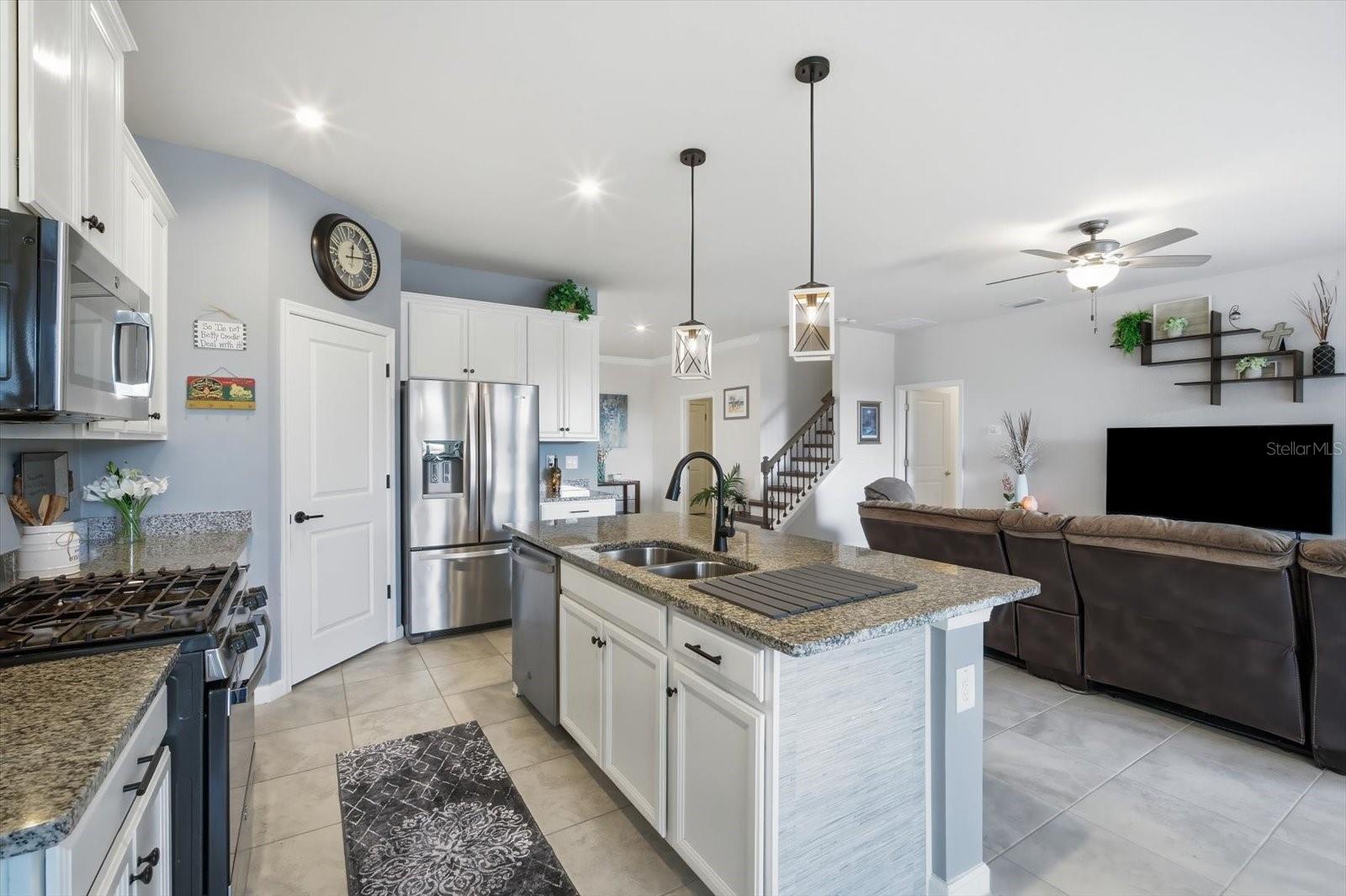 Open kitchen with stainless steel appliances and granite countertops
