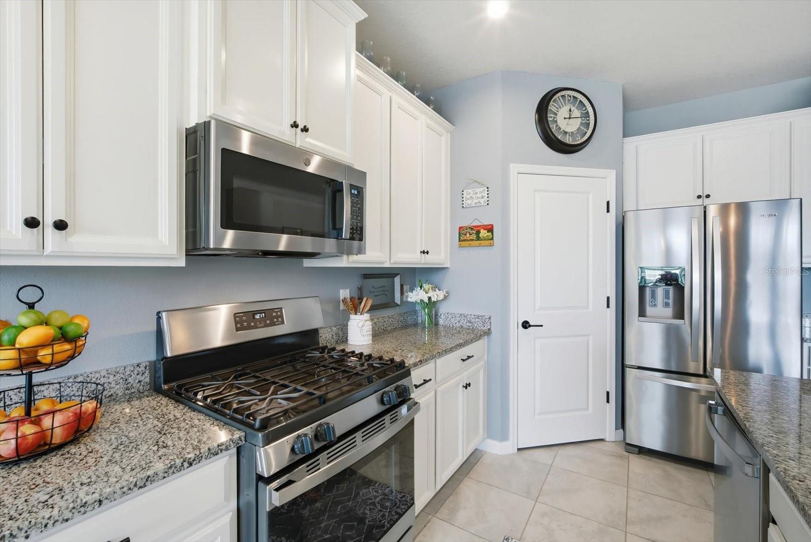 Open kitchen with stainless steel appliances and granite countertops