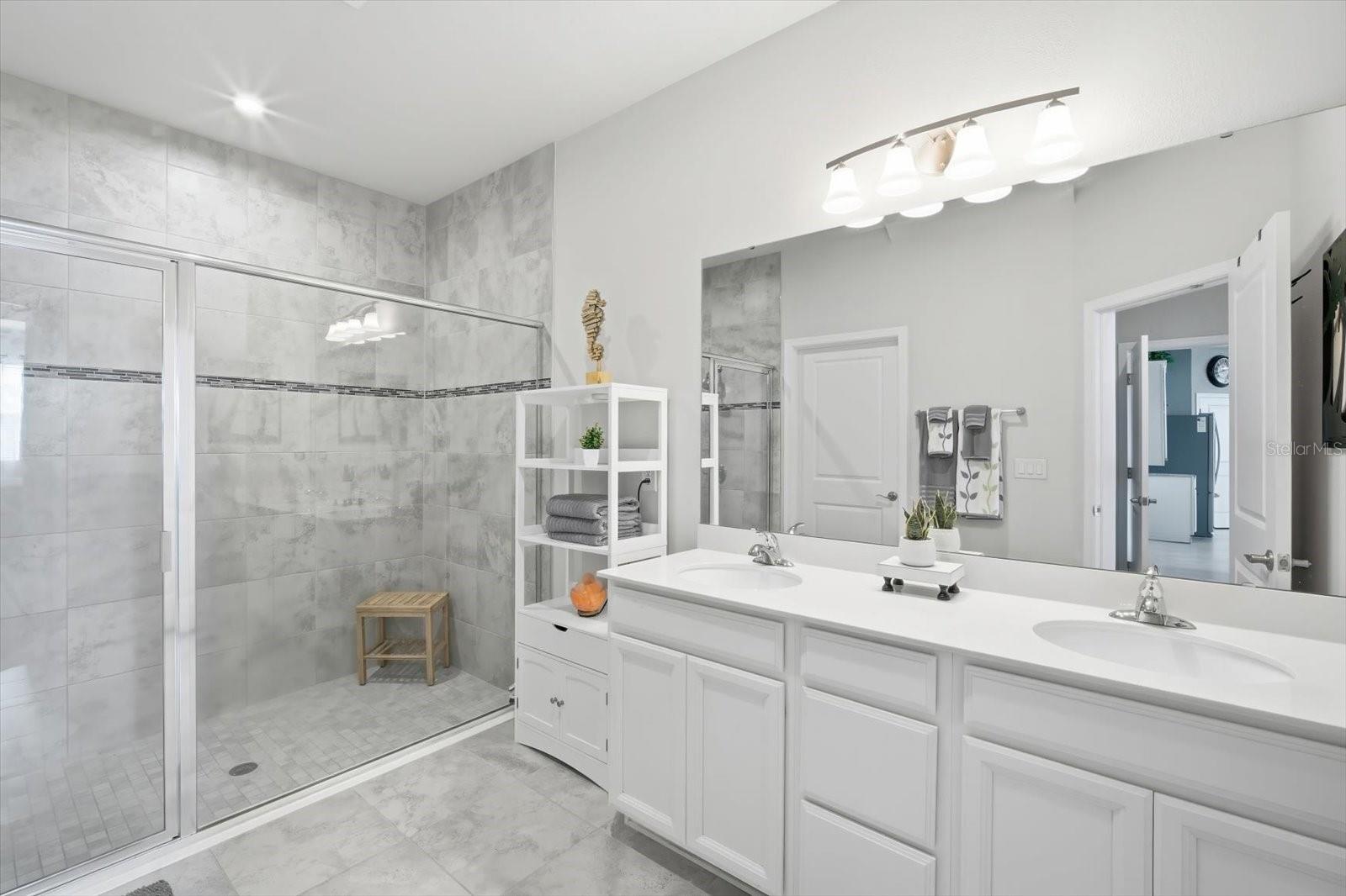 En-suite bathroom with dual vanities and walk-in shower