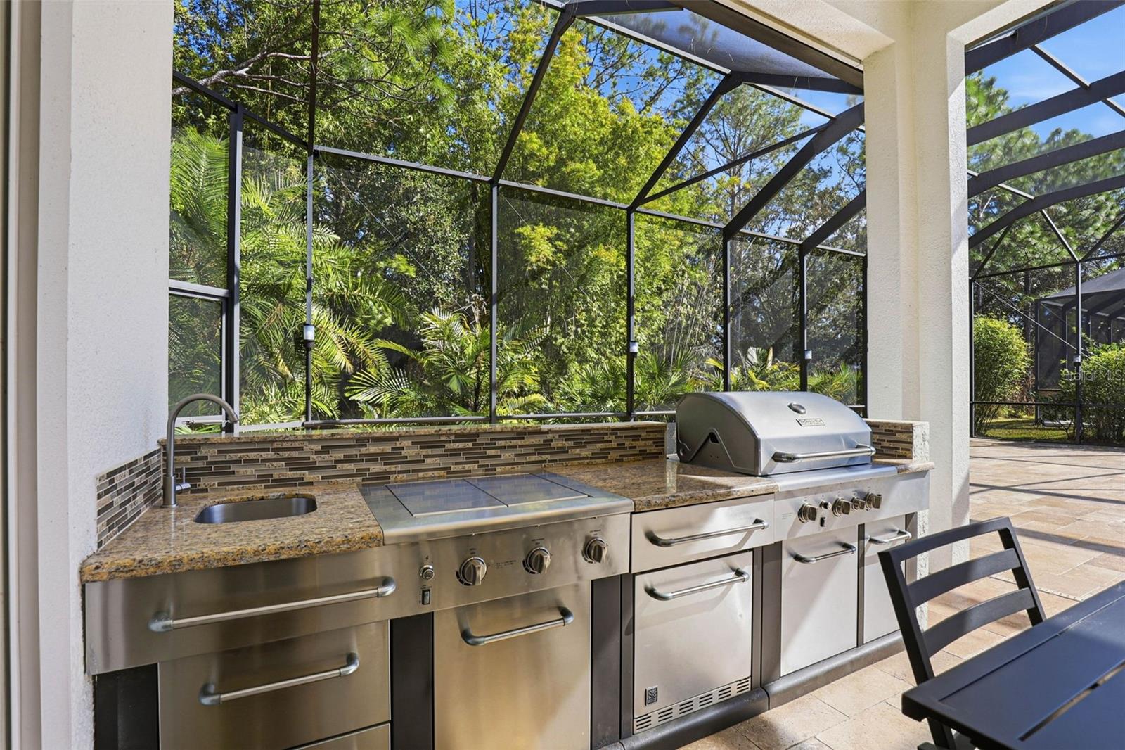 Out Door Kitchen Equipped With: Built-in Grill, Fridge, Cooktop & Sink.