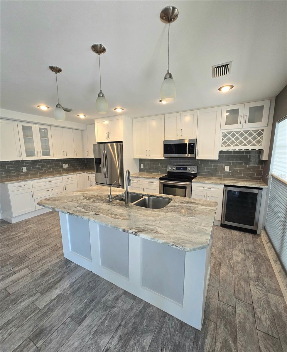 Large and new kitchen. Look at that island and all that nice Quartz.