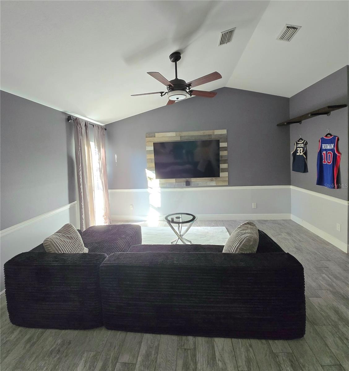 Living room with high ceilings and custom accent wall.
