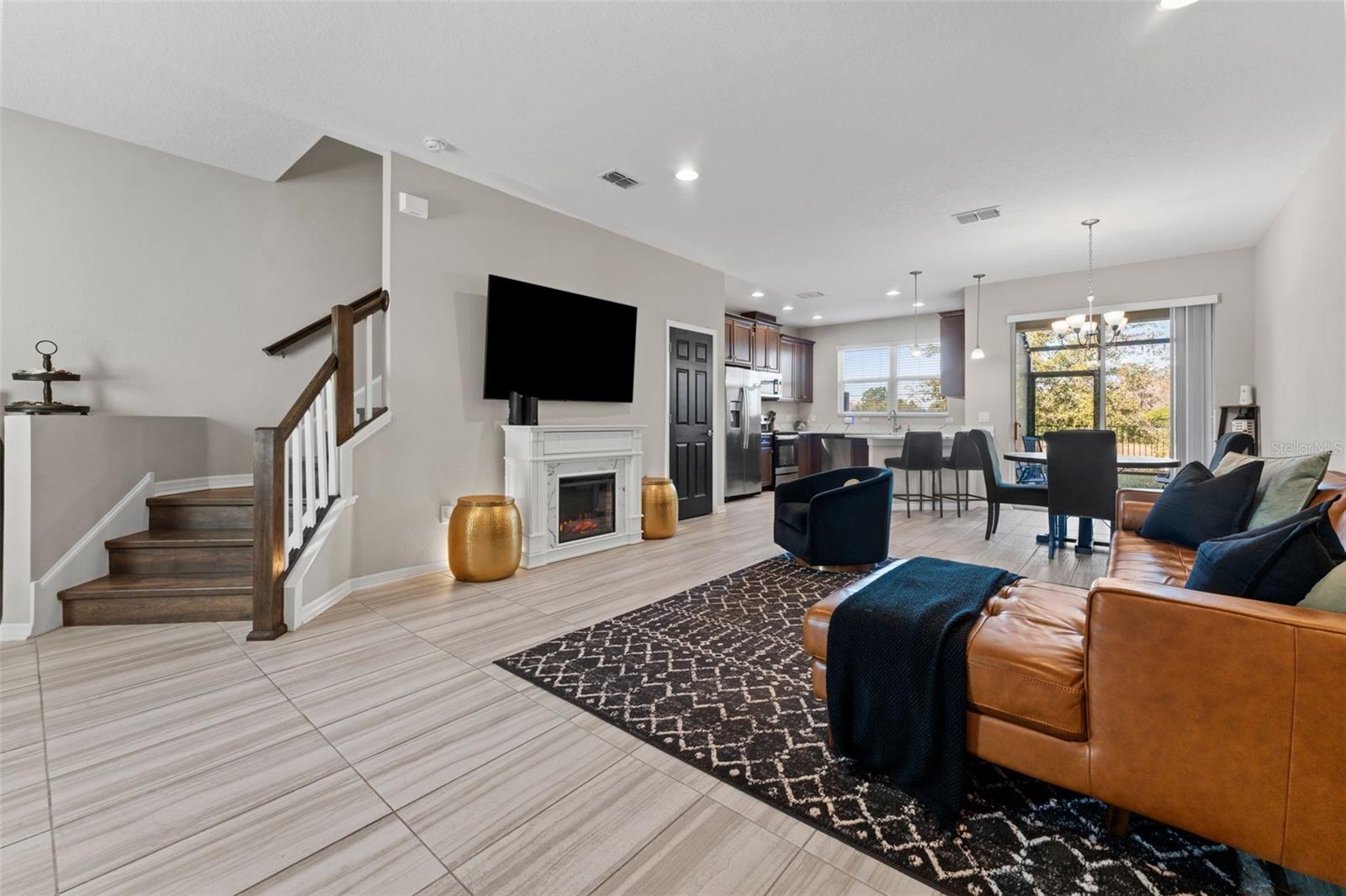 Spacious Open Floor Plan With Wooden Staircase Ascending to 2nd Floor