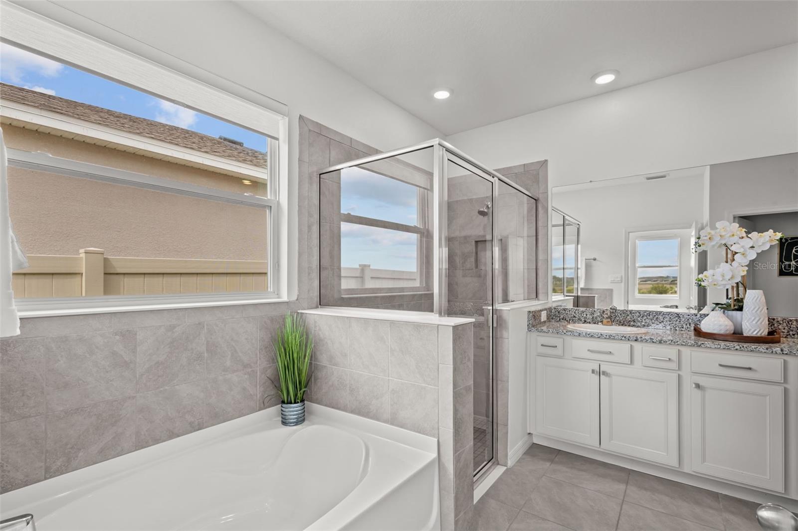Spa-inspired primary bathroom with dual vanities, a large walk-in shower, and elegant finishes throughout.