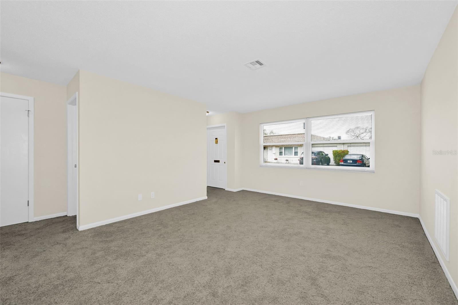 Living room looking at front door and view to the front of the property. Everyone has a private garage between the units!  New carpet, fresh paint, so perfect!!