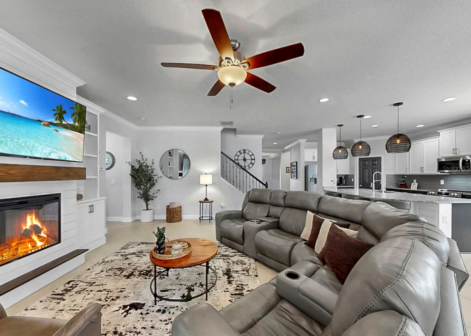 Living room with custom built-in shelving, storage and electric fireplace