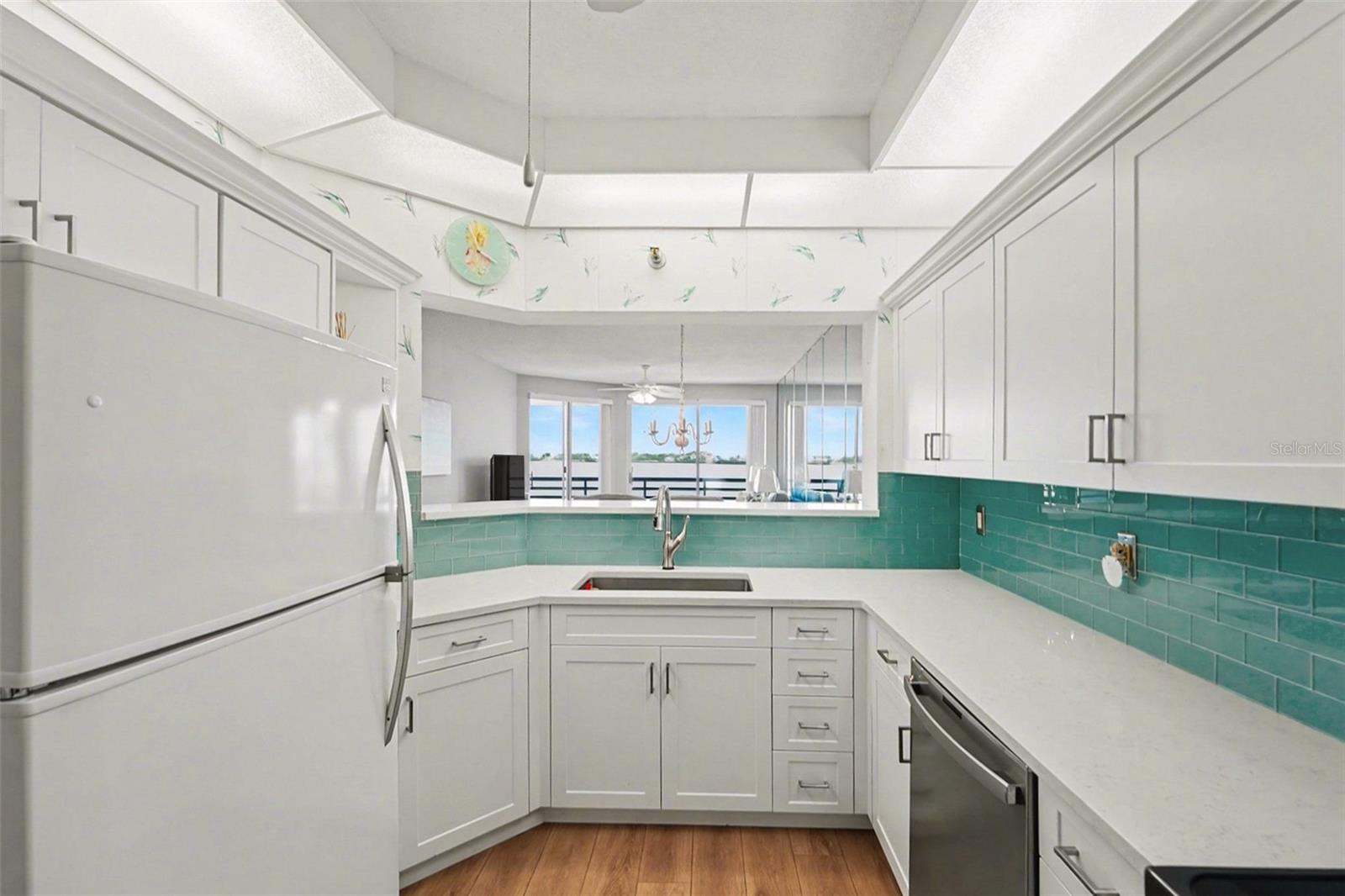 The white shaker cabinets, quartz counters & backsplash are new in 2024