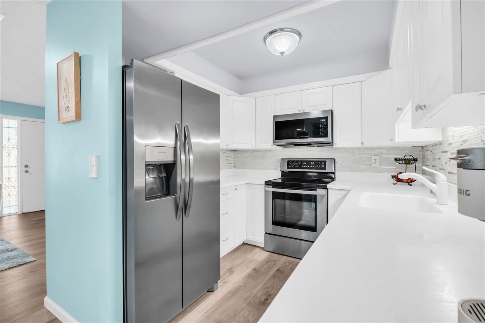 Beatifully updated kitchen with sleek stainless appliances, updated cabinetry, & stone-like countertops~