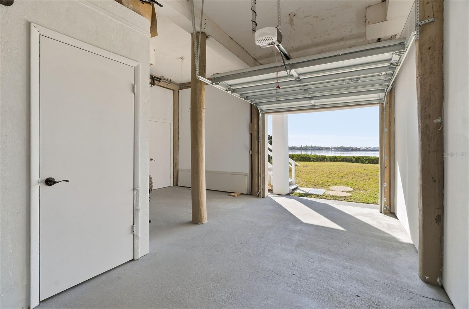 looking out the second rear garage door. To the right is the access to the screened in patio. To the left is 1/2 bath and access to the one car garage