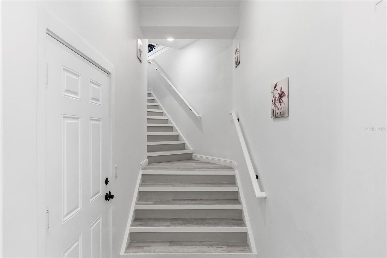 Interior entry stairs from front entry. 2 car garage entry door on left.