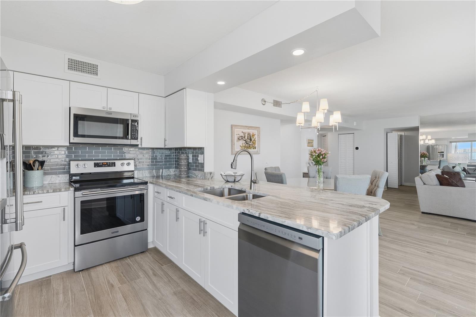 The kitchen and dining room are separated by an expansive bar creating an inviting space for gatherings.