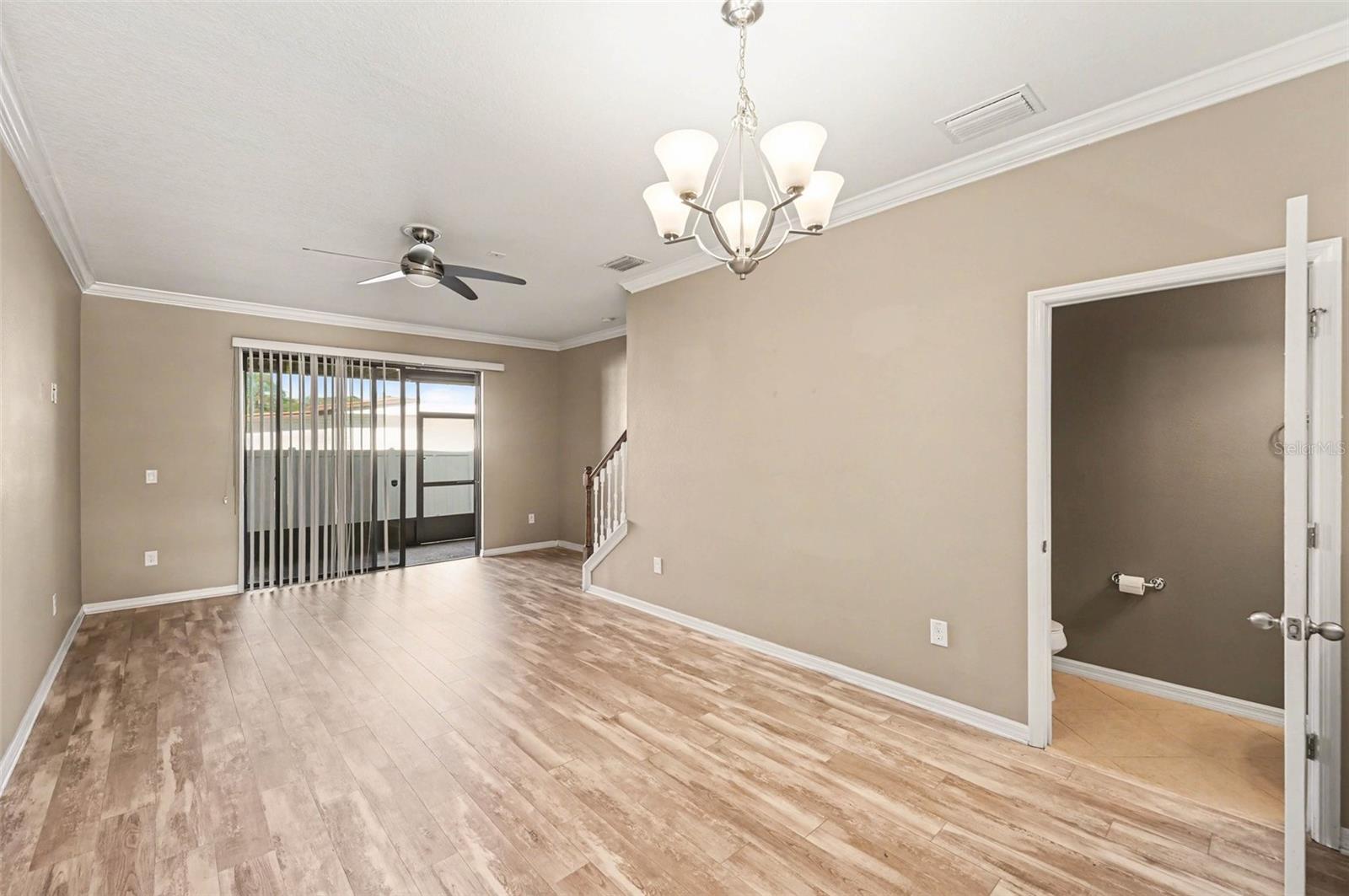 Living Room: Expansive living space with durable flooring and large sliding doors leading to the rear porch