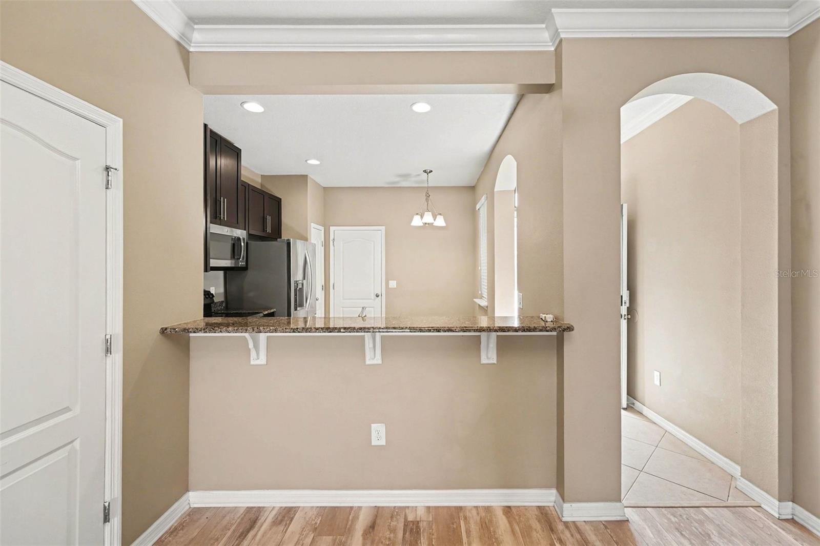 Modern kitchen featuring stone counters, a breakfast bar, and a full suite of included appliances.