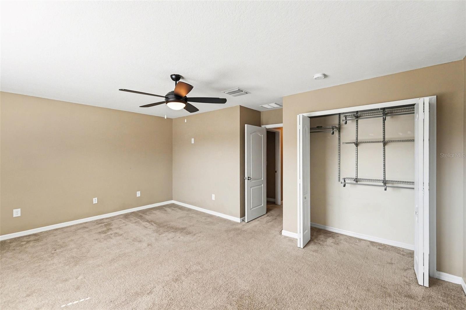 Large second bedroom featuring neutral tones and a built-in closet.
