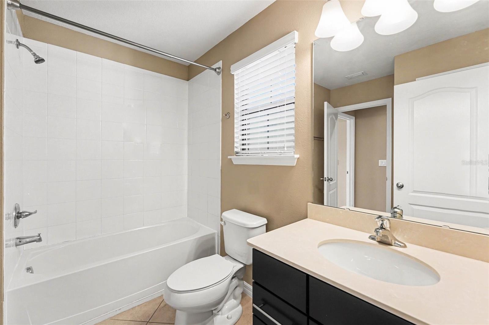 Large second bedroom featuring neutral tones and a built-in closet.