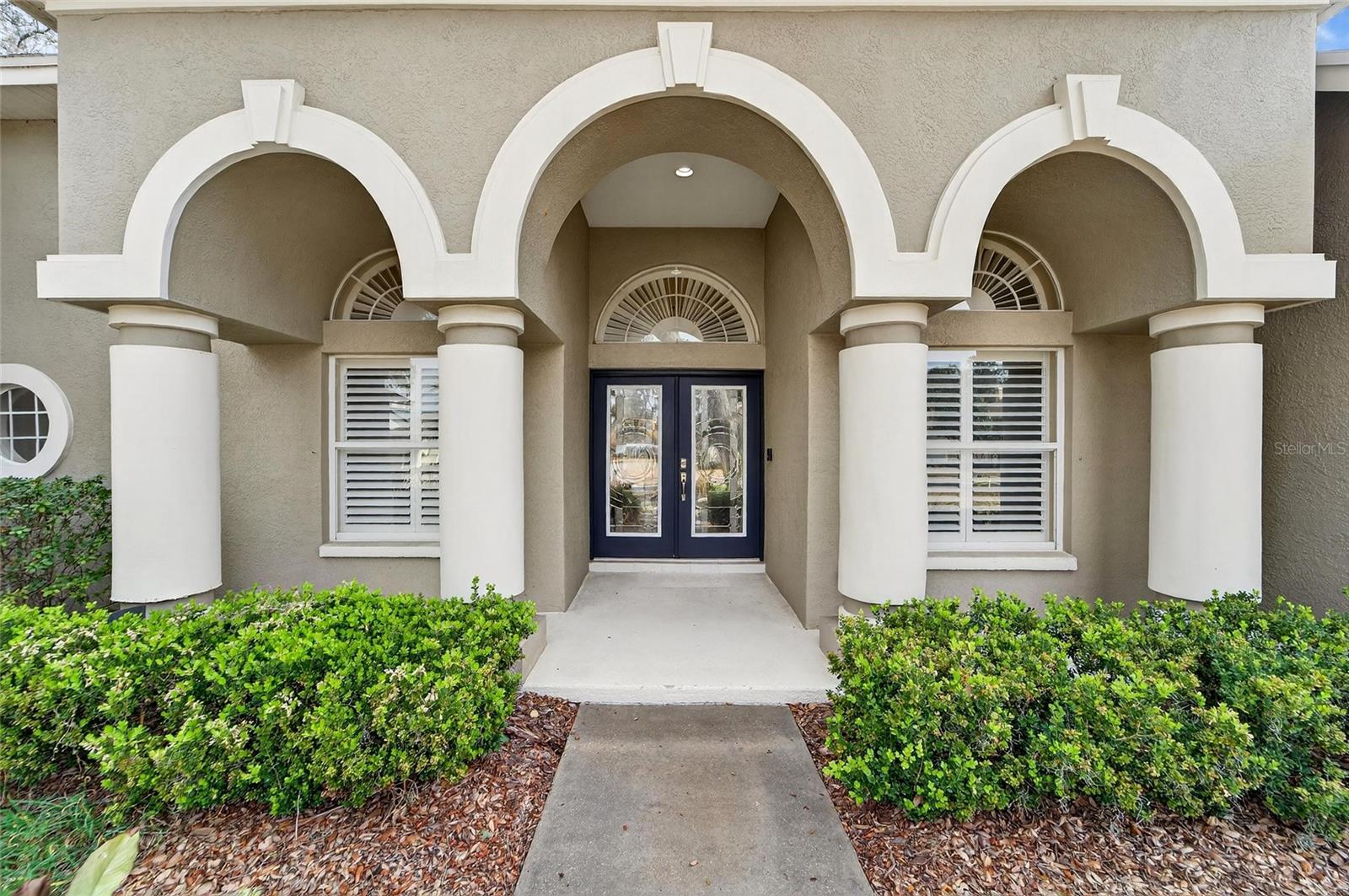Grand front entrance with custom etched/designed glass double doors