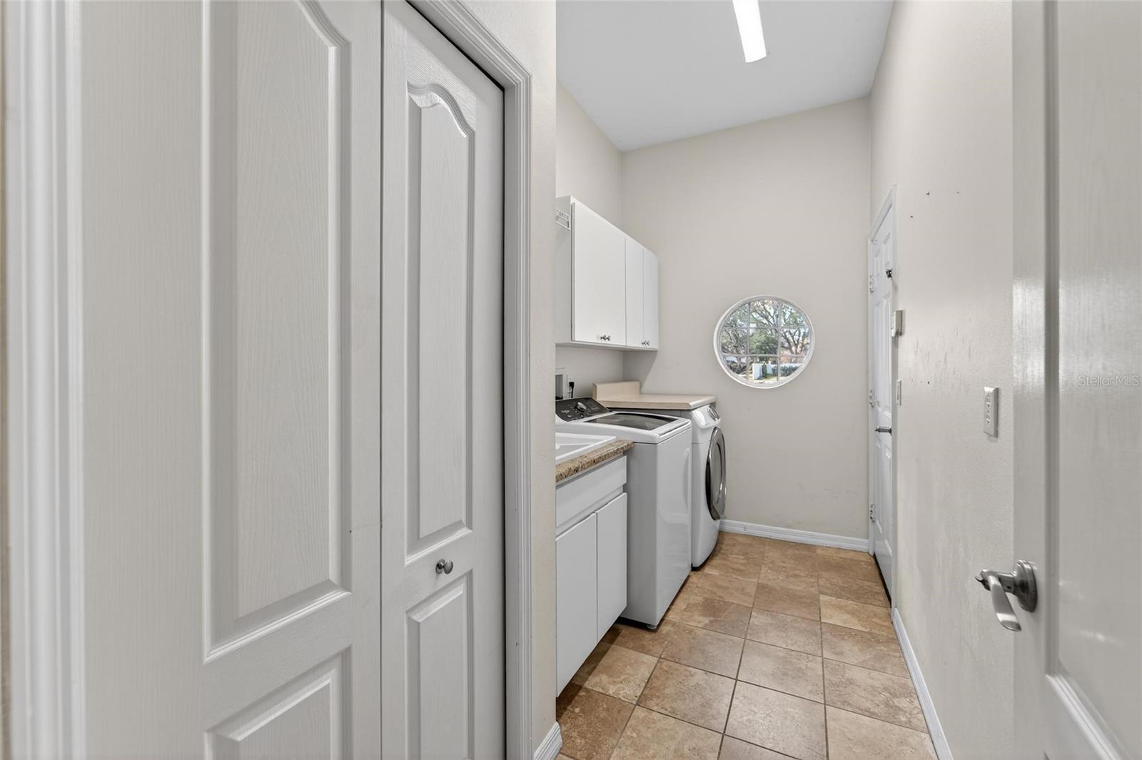 Generously sized laundry room with closet and utility sink