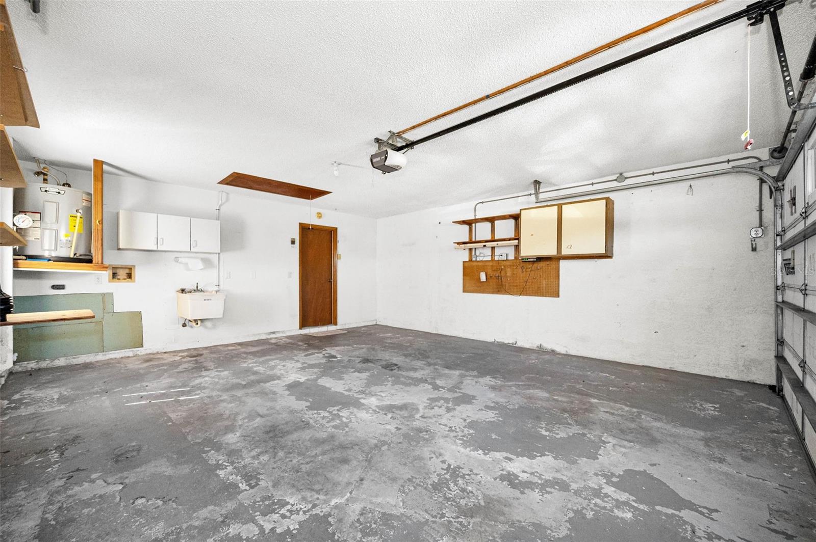 Garage! Features a Washer and Dryer hookup, Utility Sink, 2018 Hot Water Heater, Attic and Storage Cabinets, Door Opener, and a reinforced Garage Door.