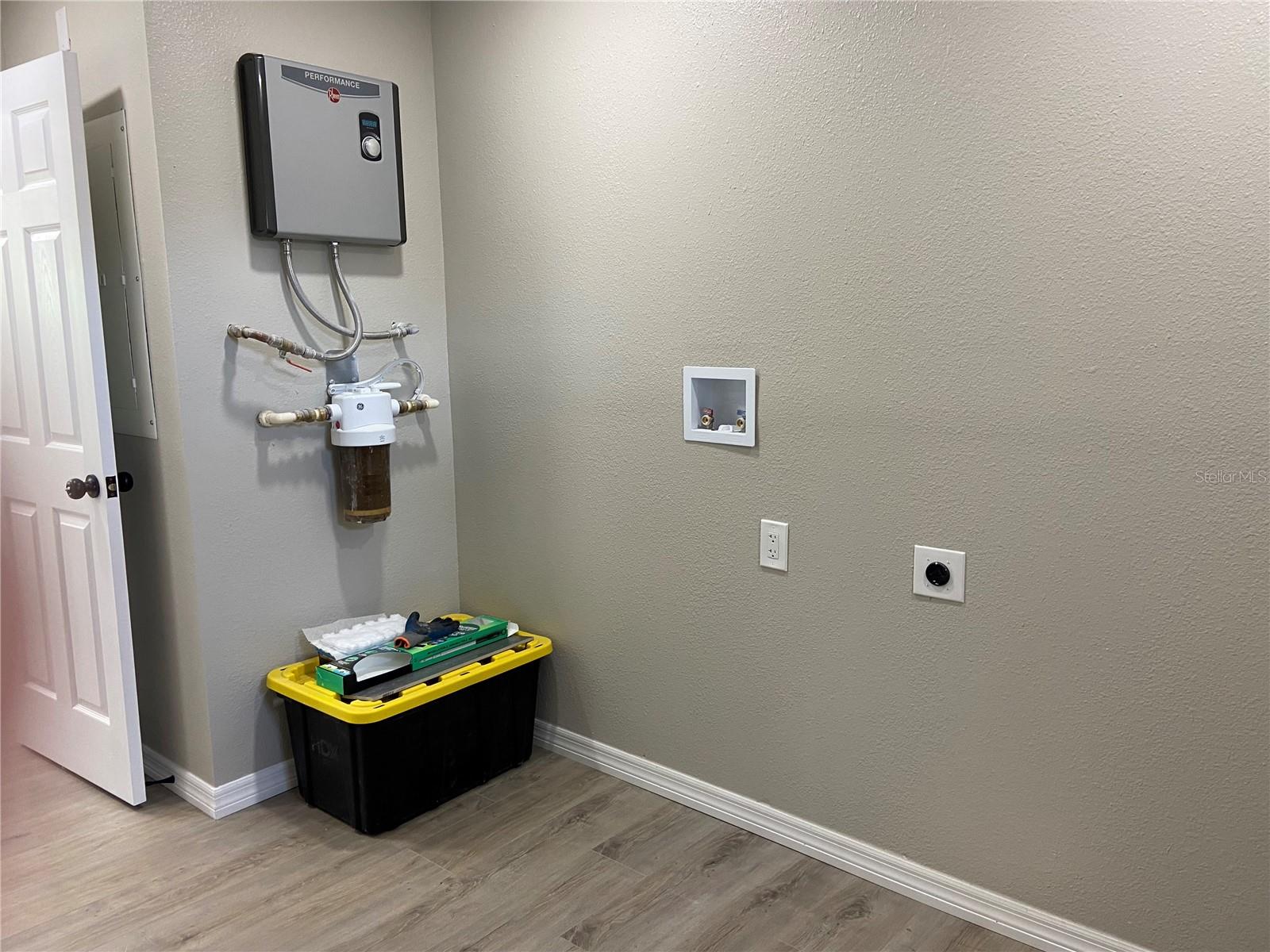 Laundry room with on demand water heater and whole house filter system