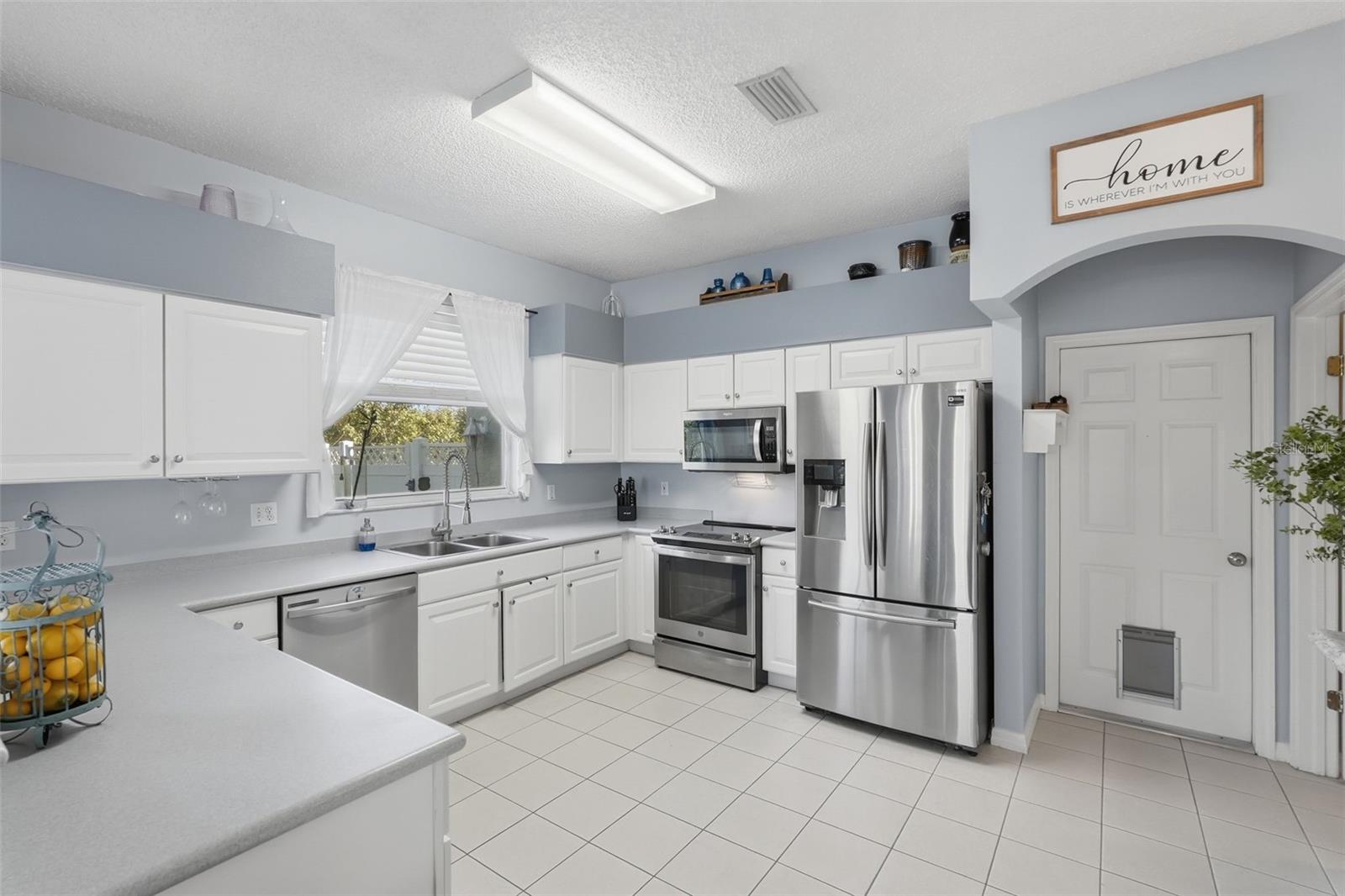 Large kitchen with attached half bathroom and door to the 3 car garage area. Stainless appliances and a natural gas connection is available to change the stove/oven from electric.