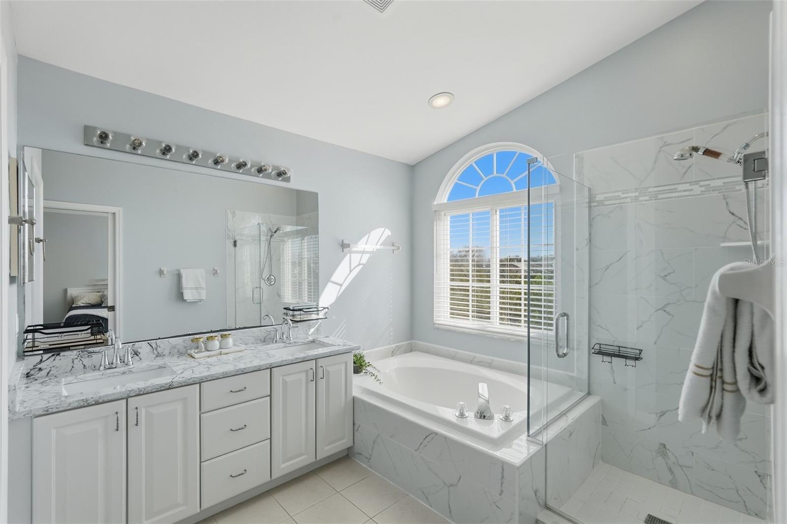 Primary bedroom ensuite.  Garden tub and walk in shower with a dual sink vanity and stone countertops.